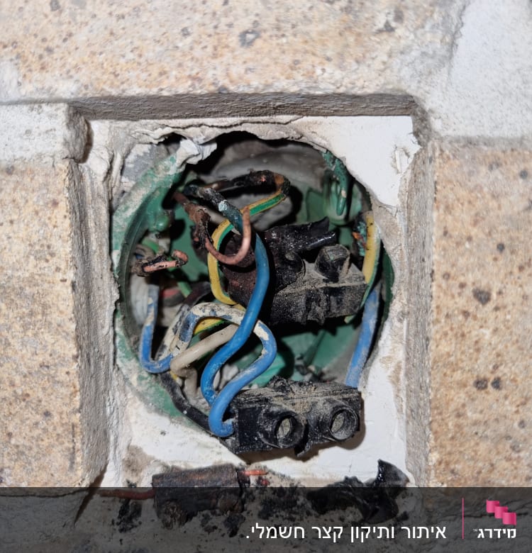 חוטי חשמל צבעוניים בקופסת חיבורים בקיר